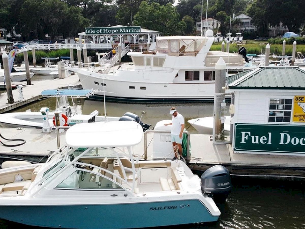 The image depicts a marina with boats docked, a small building labeled 